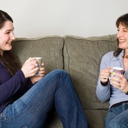 2 womens laughing sat on sofa.jpg